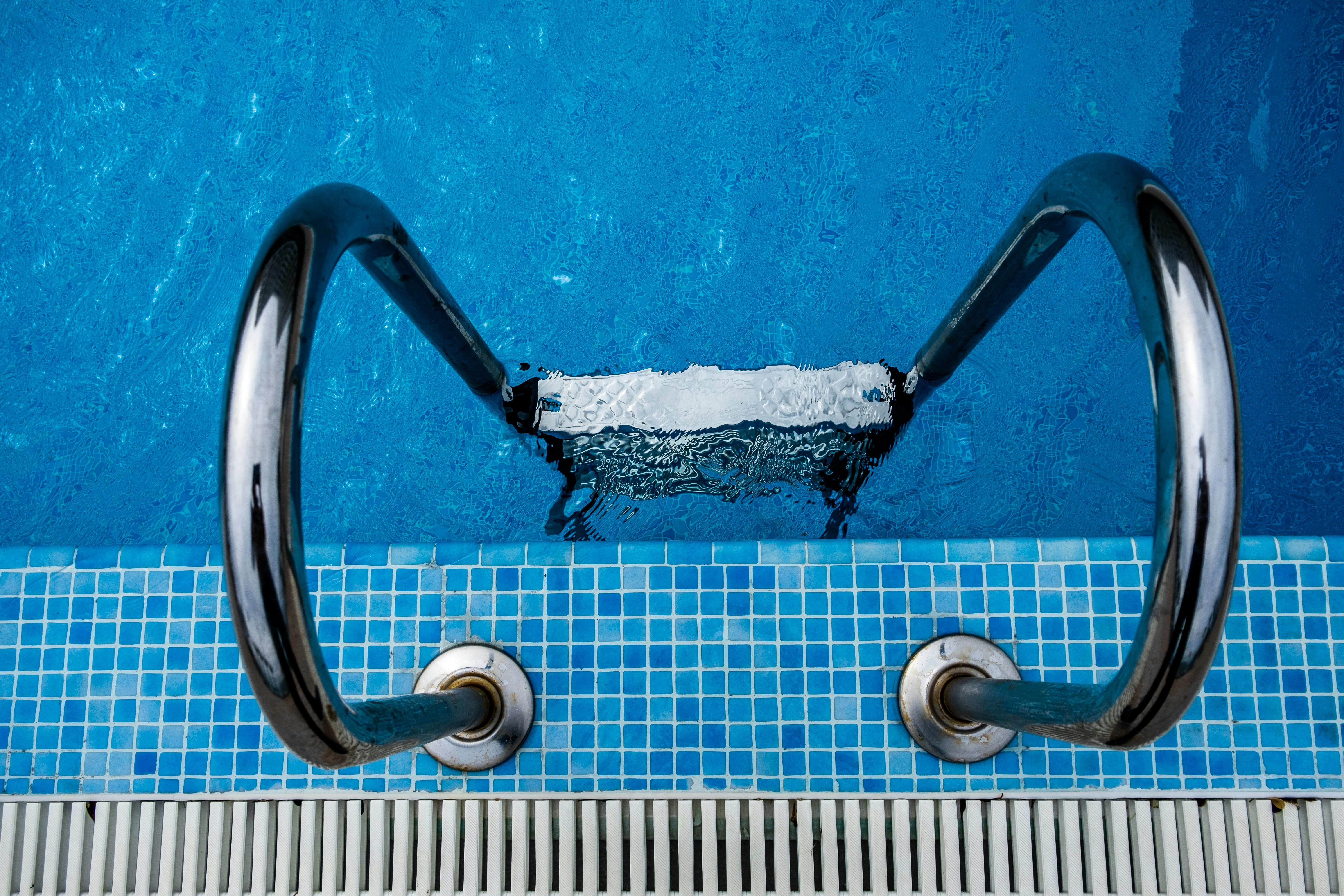 Top-down pool ladder detail over blue water