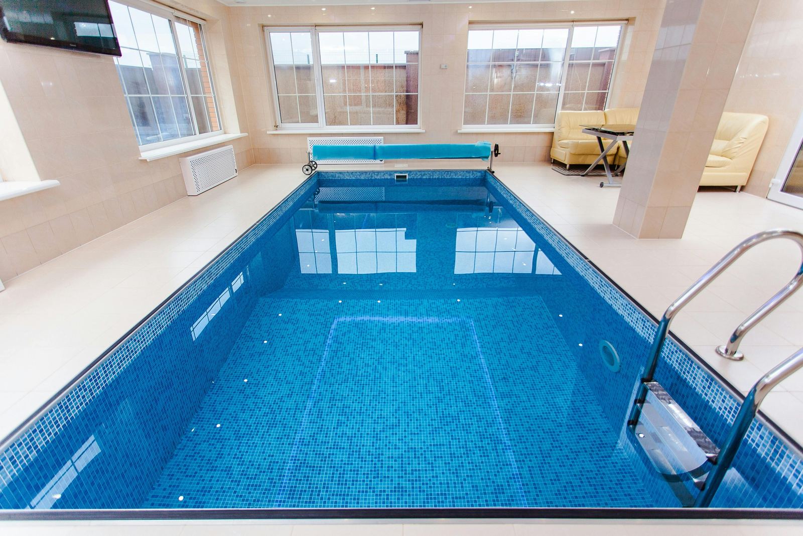 Piscina techada de azulejo con enrollador de cubierta
