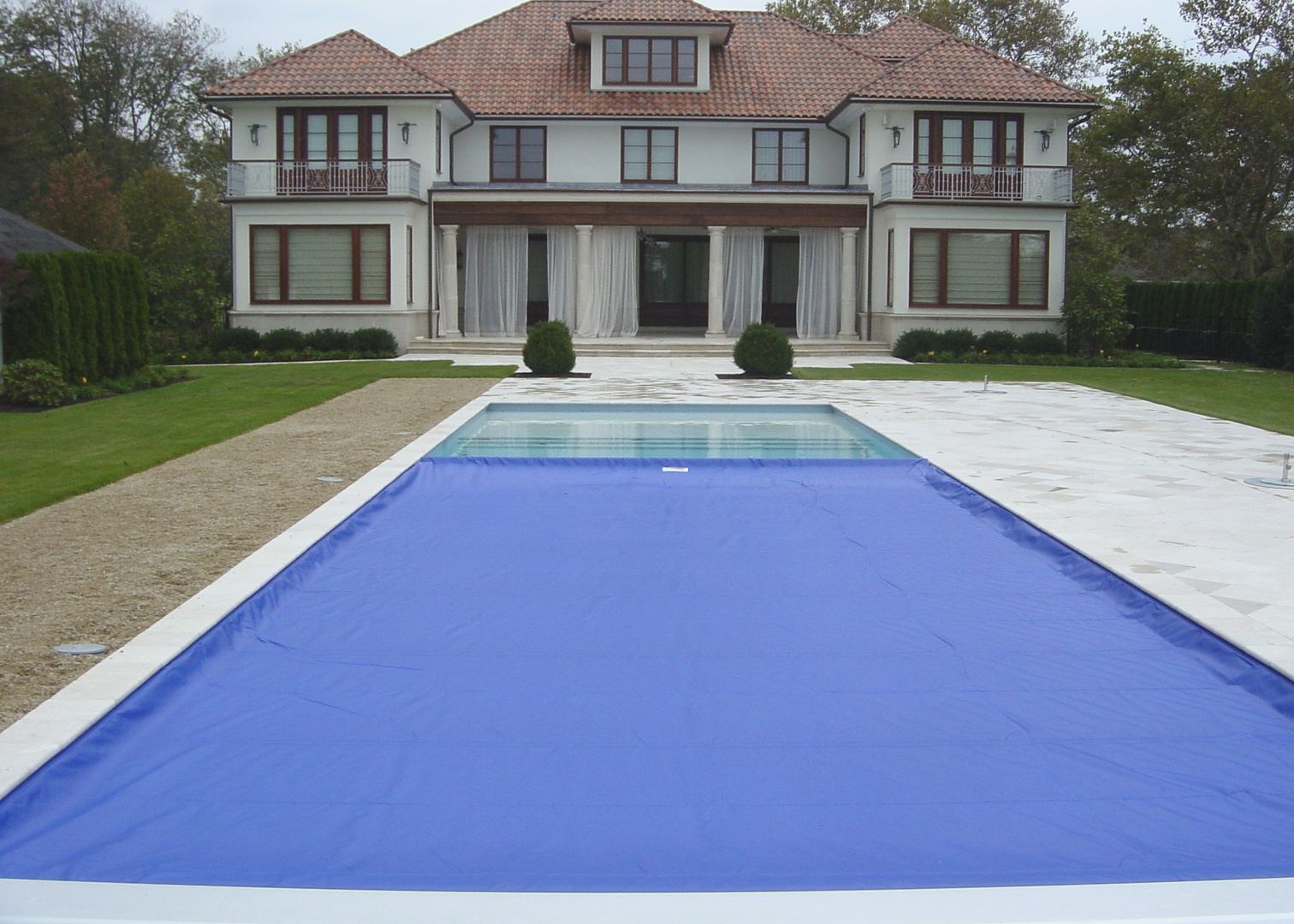 Cubierta automática azul cerrada sobre una piscina residencial
