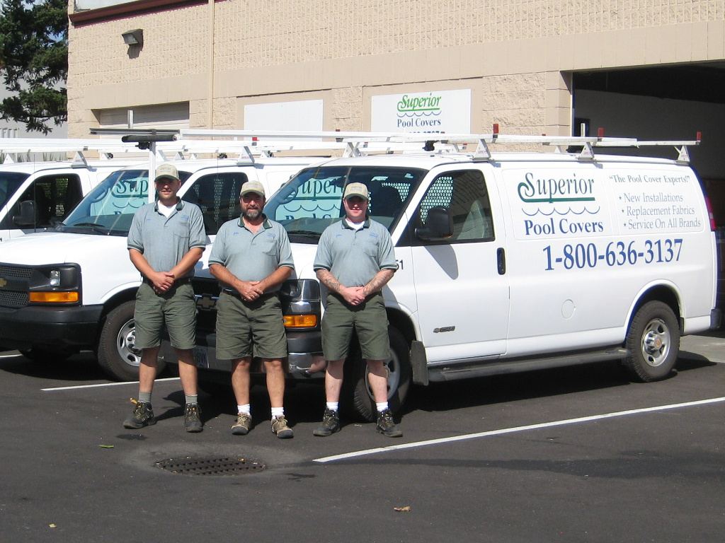 Equipo de Superior Pool Covers frente a sus camionetas de servicio